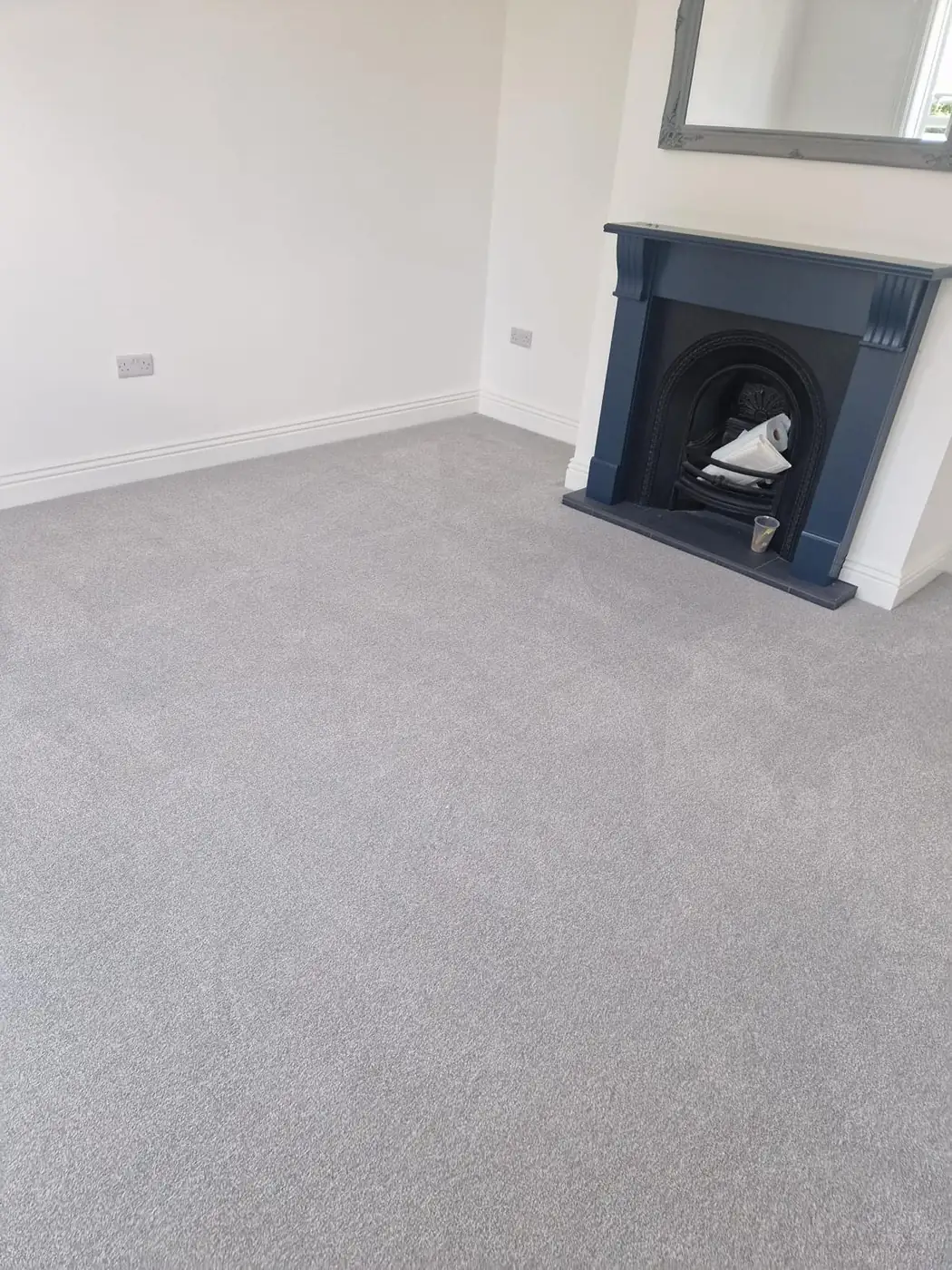 Living room carpet installation with fireplace